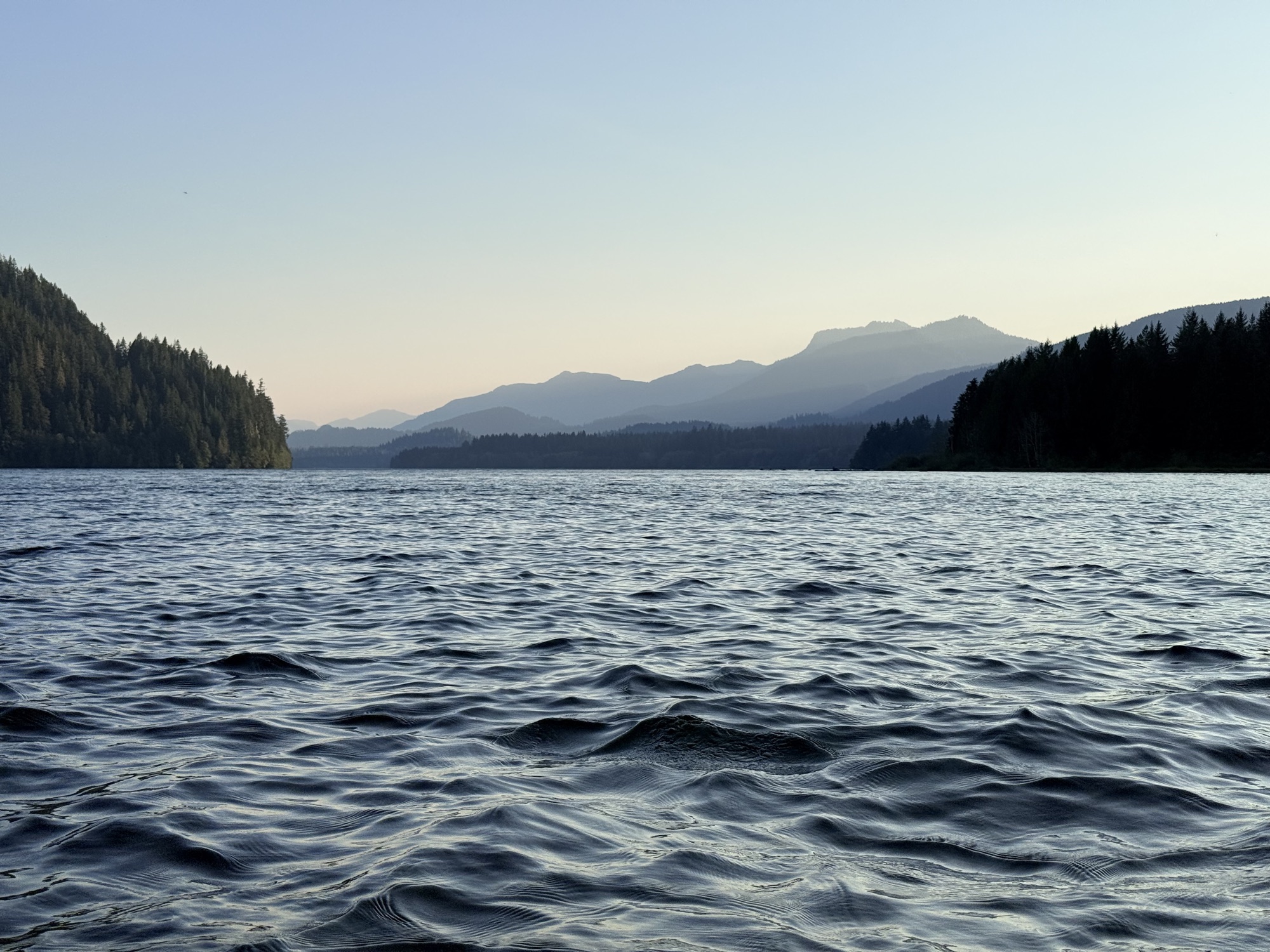 Sunset photo of Baker Lake, with water in the foreground and mountains in the background.